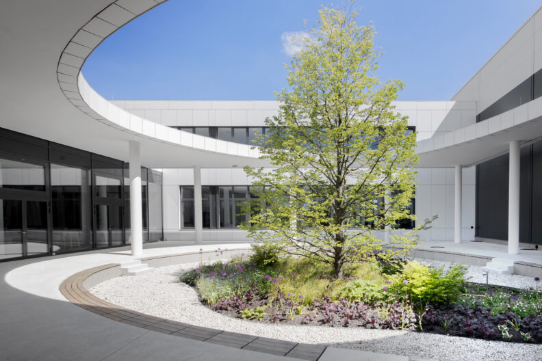 2022_B19_Harting-EDC-Espelkamp-Architecture-9s-3deluxe_06 Außenperspektive begrünter, organisch ausformulierter Innenhof der HARTING European Distribution Center