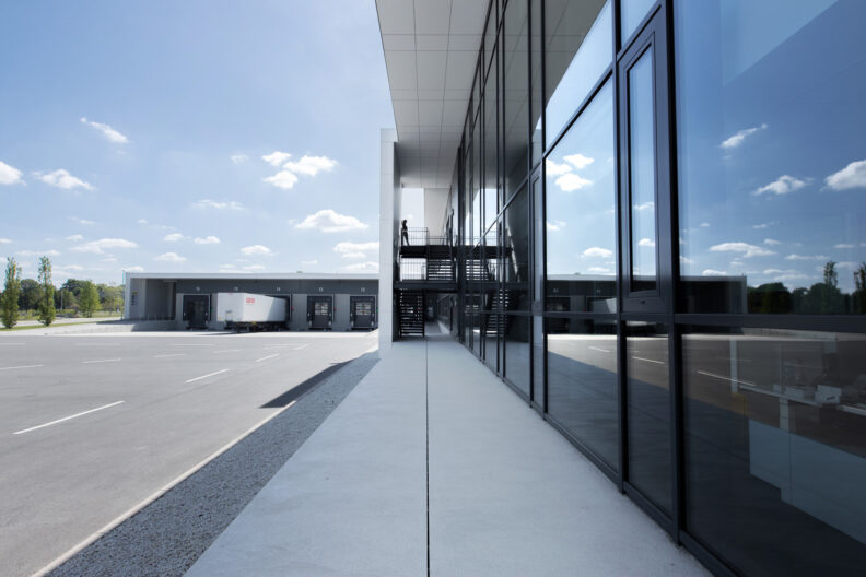 2022_B19_Harting-EDC-Verwaltungsbau-Espelkamp-Architektur-9s-3deluxe_02 Außenperspektive überdachter Schwellenraum Innen Außen der HARTING European Distribution Center