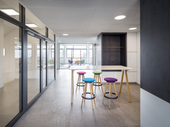 B25_PLC_10-2021_0244 Innenperspektive Büroräumlichkeiten mit offenen Kommunikationszonen und verglasten Meetingräumen im Neubau der Firma PLC2 Design