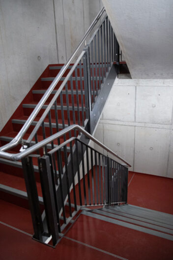 Innenperspektive Treppenhaus mit Farbakzent roter Boden im Neubau Logistik- und Lagergeb&auml;ude