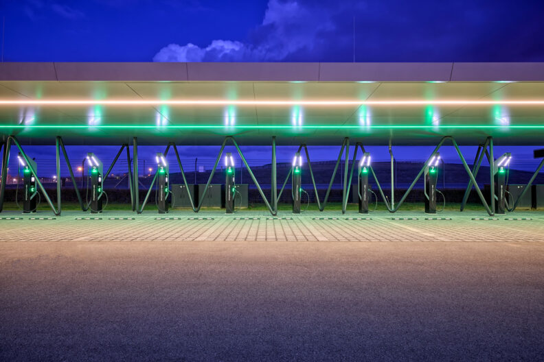 Ansicht der beleuchteten &Uuml;berdachung der Schnellladestation Porsche Leipzig bei D&auml;mmerung