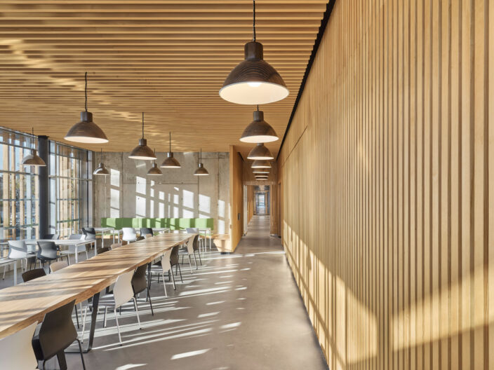 Innenraumperspektive lichtdurchflutete Cafeteria mit Holzlamellenw&auml;nden der Neugestaltung Betriebsstandort Deckerstra&szlig;e