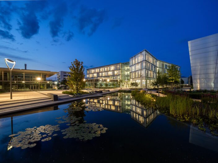 Perspektive Konferenzgeb&auml;ude Sartorius Campus - Blick &uuml;ber Wasserbecken bei Nacht